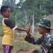 Prajurit TNI Bersama Rido Bocah yang Antusias Melihat Preses Pembukaan Jalan Lewat Program TMMD ke-116. (Foto : Bagas)