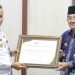 Bupati Tanjab Barat, Drs. Anwar Sadat saat Menerima Penghargaan yang Diserahkan Kepala Kantor Wilayah Kemenkumham Jambi. (Foto : Dok Prokopim TJB)