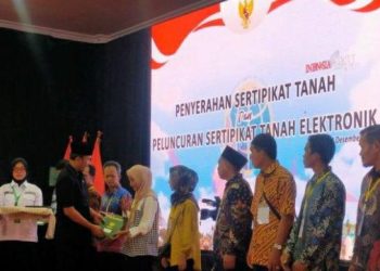 Ketua DPRD Provinsi Jambi Saat Menyerahkan Sertifikat Tanah Kepada Perwakilan Warga. (Foto: Dok. Humas).