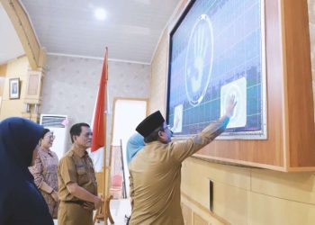 Bupati Menyentuh Layar Videotron Tandah Diluncurkannya Aplikasi SRIKANDI dan GNSTA. (Foto: Dok. Prokopim TJB).