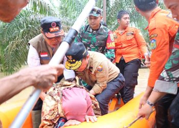 Gubernur Al Haris saat Membantu Evakuasi Lansia Korban Banjir di Tebo. (Foto: Dok. Diskominfo).