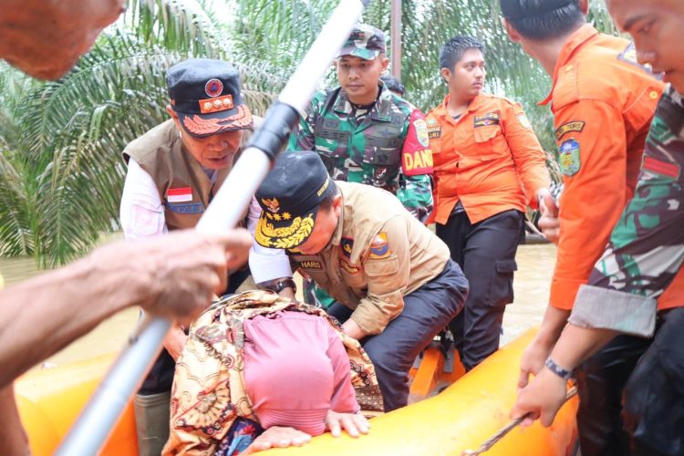 Gubernur Al Haris saat Membantu Evakuasi Lansia Korban Banjir di Tebo. (Foto: Dok. Diskominfo).