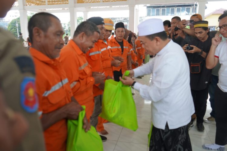 Gubernur Jambi Al Haris saat menyerahkan bantuan sembako kepada petugas kebersihan Kota Jambi, Jumat (22/3). / Foto/Ist