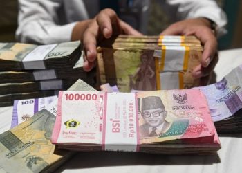 Petugas menyusun uang pecahan rupiah di Jakarta, Rabu (31/1/2024). ANTARA FOTO/Muhammad Adimaja/foc